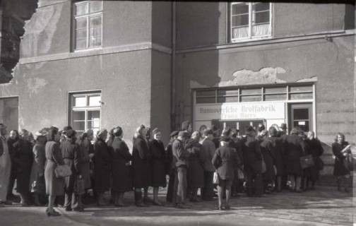 ARH NL Koberg 668, Einkaufsschlange vor der Hannoverschen Brotfabrik Franz Harry bei Vier Grenzen, Hannover, 1945