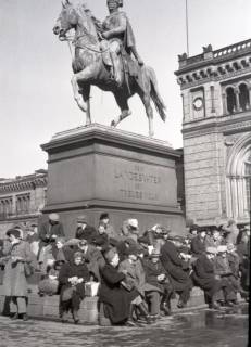 ARH NL Koberg 5029, Personen unterm Ernst-August-Denkmal (vermutlich Geflüchtete) vor dem Hauptbahnhof, Hannover, 1945