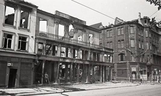 ARH NL Koberg 9420, Zerstörte Häuser, Georgstraße Ecke Windmühlenstraße, unten ein Feuerschutzpolizist beim Löschen, Hannover, 1943