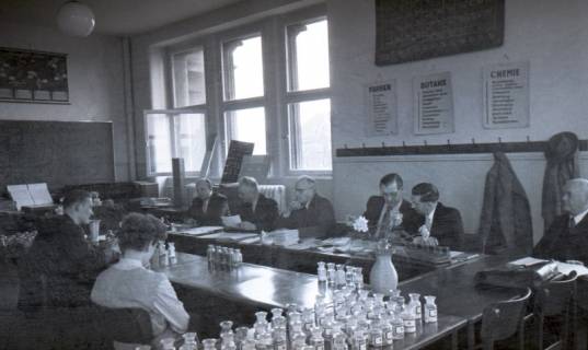 ARH NL Koberg 9671, Sechs Männer in Anzügen sitzen zwei jungen Personen in einem Lehrraum gegenüber, eventuell eine Prüfung, Hannover?, 1953