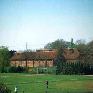 ARH NL Machinowski 156, Blick auf ein Fußballfeld mit Ställen im Hintergrund, Jeinsen, 1981