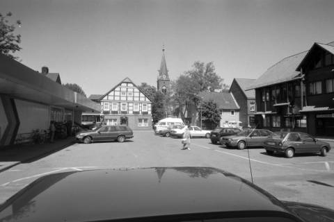 ARH NL Mellin 01-040/0016, Blick über den Parkplatz an der Langen Straße auf die St. Laurentiuskirche, Wustrow (Wendland), nach 1989
