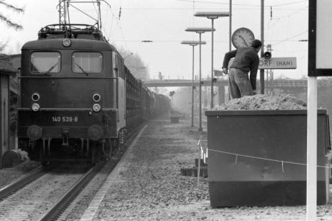 ARH NL Mellin 01-150/0018, Arbeiter am Bahnhof neben einem einfahrenden Zug, Burgdorf, wohl 1971