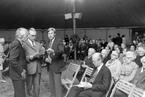 ARH NL Mellin 01-176/0003, Links drei Männer im Gespräch, darum herum sitzende Menschen in einem Zelt, ohne Datum