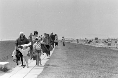 ARH NL Mellin 01-197/0017, Menschen spazieren neben dem Strand, Neuharlingersiel, ohne Datum