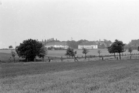 ARH NL Mellin 02-011/0005, Blick über ein Feld auf einige Häuser, ohne Datum