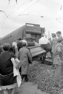 ARH NL Mellin 02-021/0015, Zwei Männer bringen einen Sarg an die Unfallstelle eines verunglückten Zuges, rechts Sanitäter der Johanniter-Unfall-Hilfe, Celle, wohl 1970