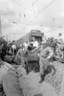 ARH NL Mellin 02-021/0016, Zwei Männer tragen einen Sarg von der Unfallstelle eines verunglückten Zuges, Celle, wohl 1970