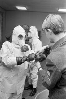 ARH NL Mellin 02-091/0009, Personen beim Anlegen von Schutzanzügen gegen Radioaktivität, ohne Datum