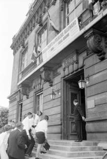 ARH NL Mellin 02-094/0014, Personen auf den Eingangsstufen des Mairie de Vanves (Rathaus), auf dem Weg zur Gala mit deutschen Volksliedern, aufgeführt vom Schulchor aus Burgdorf, Vanves, ohne Datum