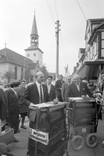 ARH NL Mellin 02-098/0008, Drehorgelspieler zum Oktobermarkt auf dem Rathausvorplatz, im Hintergrund die Pankratiuskirche, Burgdorf, ohne Datum