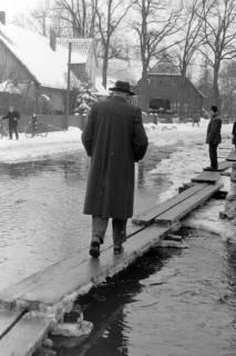 ARH NL Mellin 02-101/0006, Holzplanken zum Überqueren einer überschwemmten Straße im Winter, um 1970