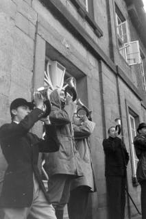 ARH NL Mellin 02-107/0019, Jagdhornbläser vor einem Gebäude, um 1970