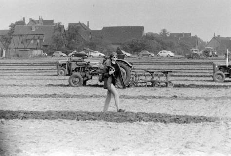 ARH NL Mellin 02-110/0004, Fotografin auf dem Feld mit Teilnehmern beim Leistungspflügen, um 1975