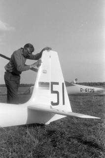 ARH NL Mellin 02-127/0003, Ein Mann beim Putzen des Seitenleitwerkes eines Segelflugzeuges (Schleicher Ka 6 E), um 1970
