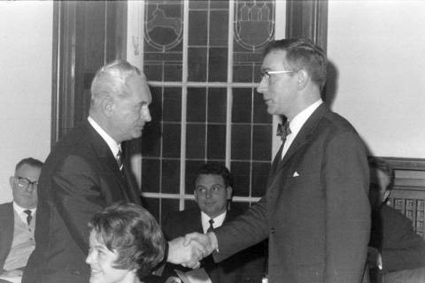 ARH NL Mellin 02-131/0005, Karl-Heinz Kannacher schüttelt Hände mit einem Mann bei einer Versammlung, um 1975