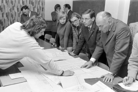 ARH NL Mellin 02-161/0006, Gruppe von Personen beim Betrachten eines Bauplans des Stadtbauamtes Lehrte, um 1975