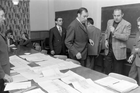 ARH NL Mellin 02-161/0007, Gruppe von Personen beim Betrachten eines Bauplans des Stadtbauamtes Lehrte, um 1975