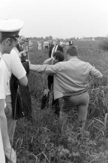 ARH NL Mellin 02-192/0005, Mick Jagger(?) mit weiteren Personen auf einem Feld, um 1975