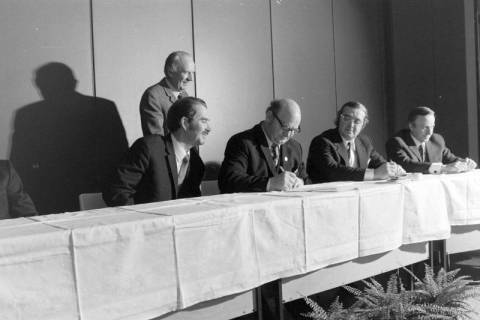 ARH NL Mellin 02-193/0008, Männer unterzeichnen Dokumente bei einer Versammlung, um 1970