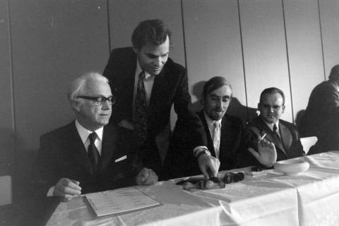 ARH NL Mellin 02-193/0009, Männer unterzeichnen Dokumente bei einer Versammlung, um 1970
