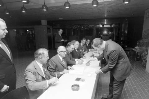 ARH NL Mellin 02-194/0013, Männer unterzeichnen Dokumente bei einer Versammlung, um 1970