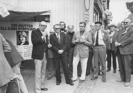 ARH Slg. Bartling 235, Wolfgang Mischnik, Vorsitzender der FDP-Fraktion im Bundestag, mit einem Mikrofon in der Hand stehend vor einem Werbestand der FDP, Neustadt a. Rbge., 1974