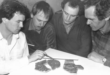 ARH Slg. Bartling 648, Vier Mitarbeiter des Bauamtes (?) am Tisch sitzend vor drei Scherben, um 1980