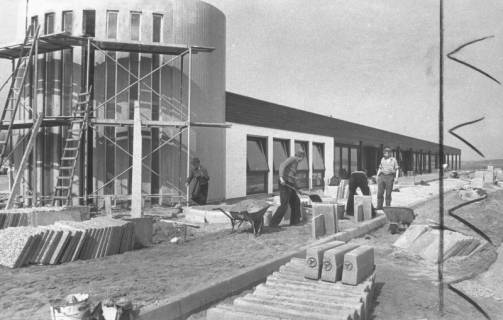 ARH Slg. Bartling 729, Großer Weg 45, Hibbe Wohnform GmbH & Co., Pflasterarbeiten vor dem im Rohbau fertiggestellten Möbelpavillon, Neustadt a. Rbge., um 1970