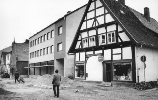 ARH Slg. Bartling 780, Windmühlenstraße 20-21, Sanierung der Straße, Blick über die Baustelle nach Südwesten auf Leffmann (später: Matheja) Herrenmoden (im Bau befindlich) und Handwerkerbedarf Ch. Ciesla (Fachwerkbau), Neustadt a. Rbge., um 1980