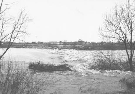 ARH Slg. Bartling 1069, Wasserfall der Leine bei Hochwasser im Spätherbst, Blick vom östlichen Ufer nach Westen auf die am gegenüberliegenden Ufer stehenden Häuser des Silbernkamps, Neustadt a. Rbge., um 1980