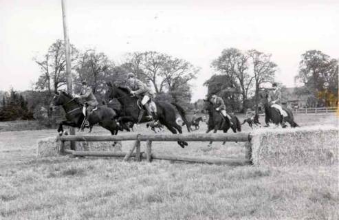 ARH Slg. Bartling 1405, Geländeritt mehrerer Reiter beim Sprung über ein Balkenhindernis im Gelände, Mandelsloh, um 1980