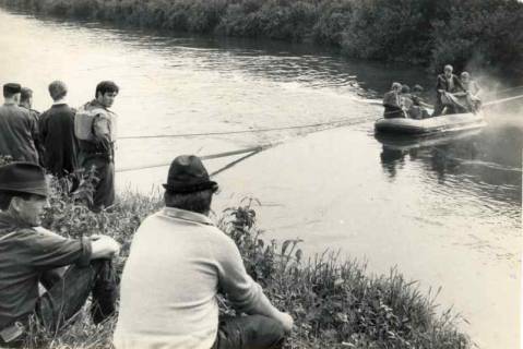 ARH Slg. Bartling 1563, Ölfilm auf dem Wasser der Leine, Entfernung durch die Feuerwehr unter Einsatz eines Bootes, links am Ufer einige Zuschauer, Bordenau, 1970