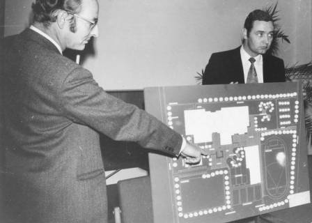 ARH Slg. Bartling 1598, Oberbaurat Georg Jonck und Hartmut Riepe präsentieren eine Tafel mit dem Lageplan eines Schulzentrums, Neustadt a. Rbge., 1971