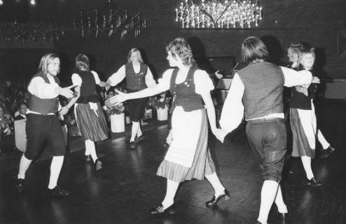 ARH Slg. Bartling 1749, Gruppe von mehreren jungen Menschen in Tracht präsentiert einen Volkstanz (Rundtanz) auf der Bühne des Freizeitzentrums, Blick über die Bühne ins Publikum, Neustadt a. Rbge., 1972
