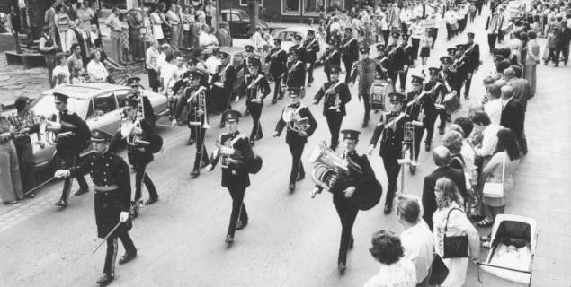 ARH Slg. Bartling 1818, Blasorchester des englischen Militärs beim Marsch durch die Marktstraße betrachtet von der Rathaustreppe, Neustadt a. Rbge., 1974