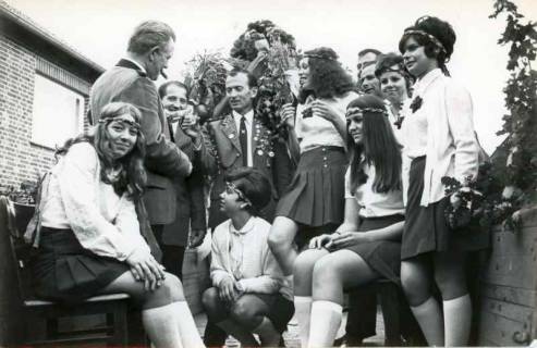 ARH Slg. Bartling 1876, Erntefest in Bordenau, Gruppe von älteren Männern in Schützenuniform, die Schnaps verteilen an Gruppe von jungen Frauen mit Stirnband, Bordenau, 1970