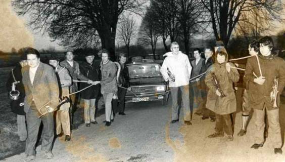 ARH Slg. Bartling 1902, Bläsergruppe mit Instrumenten im Dunkeln beim Ziehen eines PKWs (AUDI 100) mit Seilen über die Leinebrücke, Bordenau, 1973