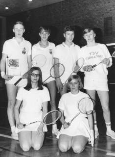 ARH Slg. Bartling 1916, Gruppe von vier Badmintonspielern (stehend) und zwei Badmintonspielerinnen (kniend) in Sportkleidung und mit Schläger in einer Turnhalle; der linke Spieler präsentiert eine Urkunde über das Erreichen des 2. Platzes, Neustadt a. Rbge., 1969