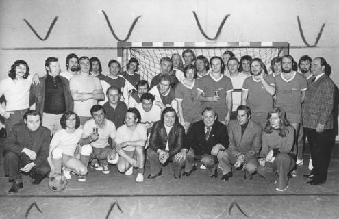 ARH Slg. Bartling 1980, Fußballturnier-Mannschaften von Betrieben mit Begleitern (locker nebeneinander kniend und stehend) im Tor der Turnhalle Am Ahnsförth, Neustadt a. Rbge., 1974
