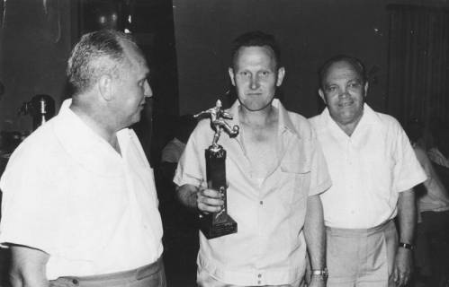 ARH Slg. Bartling 1987, Sportler in Freizeitkleidung einen Fußballpokal zeigend, links und rechts begleitet von einem Kollegen (l.: Erich Eichmann), Blick von vorn, 1969