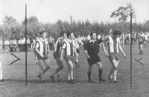 ARH Slg. Bartling 1999, Platzverweis eines Feldspielers des FC Wacker Neustadt durch den Schiedsrichter, verfolgt von drei protestierenden Mannschaftskollegen, Blick von der Seite, 1972