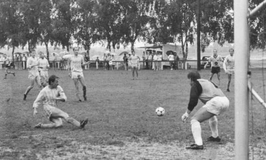 ARH Slg. Bartling 2008, Schuss aufs Tor in einem verregneten Spiel, Blick von der Torlinie am linken Torpfosten nach rechts, um 1975