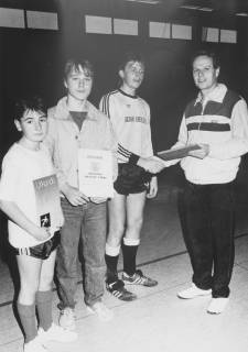 ARH Slg. Bartling 2041, Verleihung von Urkunden an drei junge Sportler in einer Turnhalle durch einen Lehrer der Realschule (?), um 1975