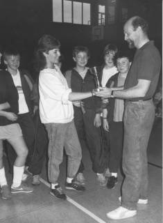 ARH Slg. Bartling 2046, Vergabe eines Pokals in einer Sporthalle durch Herrn Friedrichsen (ehemaliger Lehrer der Otto-Hahn-Schule Wunstorf) an die Spielführerin einer Basketball-Schülerinnenmannschaft (?), um 1985