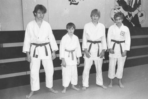 ARH Slg. Bartling 2054, Gruppenporträt von vier jugendlichen Karateka im Karate-Gi in einem Übungsraum mit bemalter Wand, um 1975