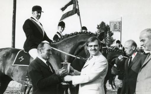 ARH Slg. Bartling 2187, Überreichung eines Pokals an N. N. durch den Kreisdirektor Wolfgang Kunze vor mehreren aufsitzenden Reitern samt zwei Reitervereinsstandarten, 1971