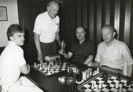 ARH Slg. Bartling 2278, Schachpartie (mit Schachuhr) zwischen Karlheinz Heider (r.) und N. N. unter den Augen von zwei weiteren Männern, Neustadt a. Rbge,, um 1973