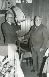 ARH Slg. Bartling 2426, Überreichung einer Urkunde an Heinrich Harmening für seine 30jährige Tätigkeit als Kreisvorsitzender des Reichsbundes durch N. N., Neustadt a. Rbge., um 1986