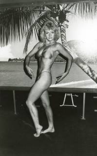 ARH Slg. Bartling 2578, Fitness-Studio, Bodybuilderin posierend mit nach unten gebogenen Armen, im Hintergrund Foto einer Palmenlandschaft, Neustadt a. Rbge., um 1985